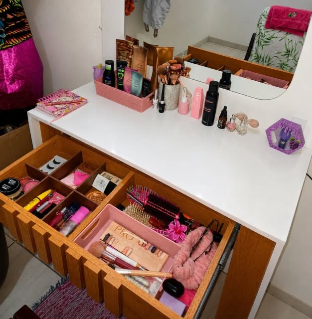 Bancada de trabalho com pincéis, paletas, bases e produtos de maquiagem organizados.